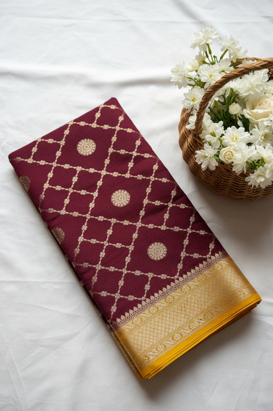 Maroon fabric with gold embroidery on a white background