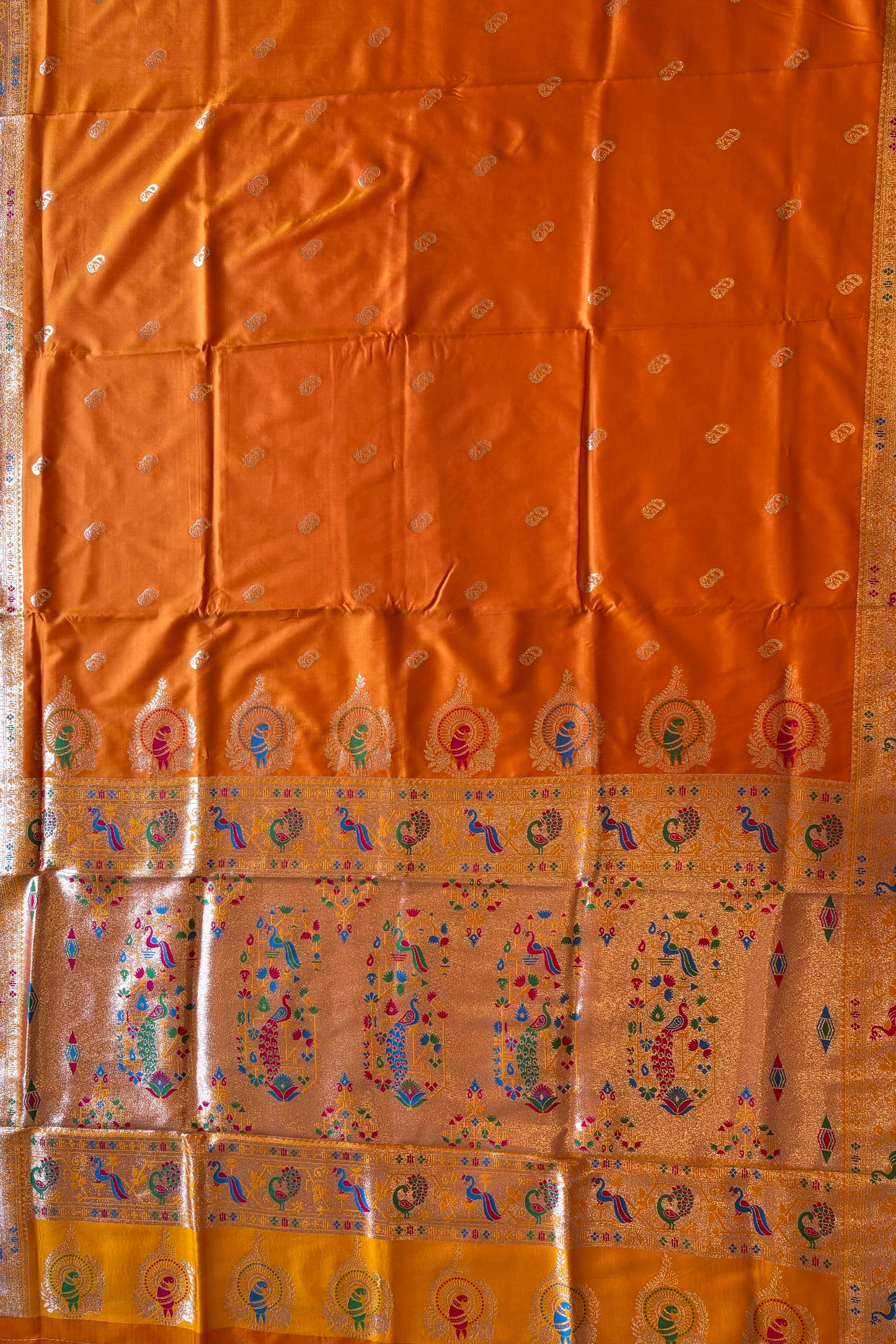 Orange fabric with colorful patterns and designs on a plain background