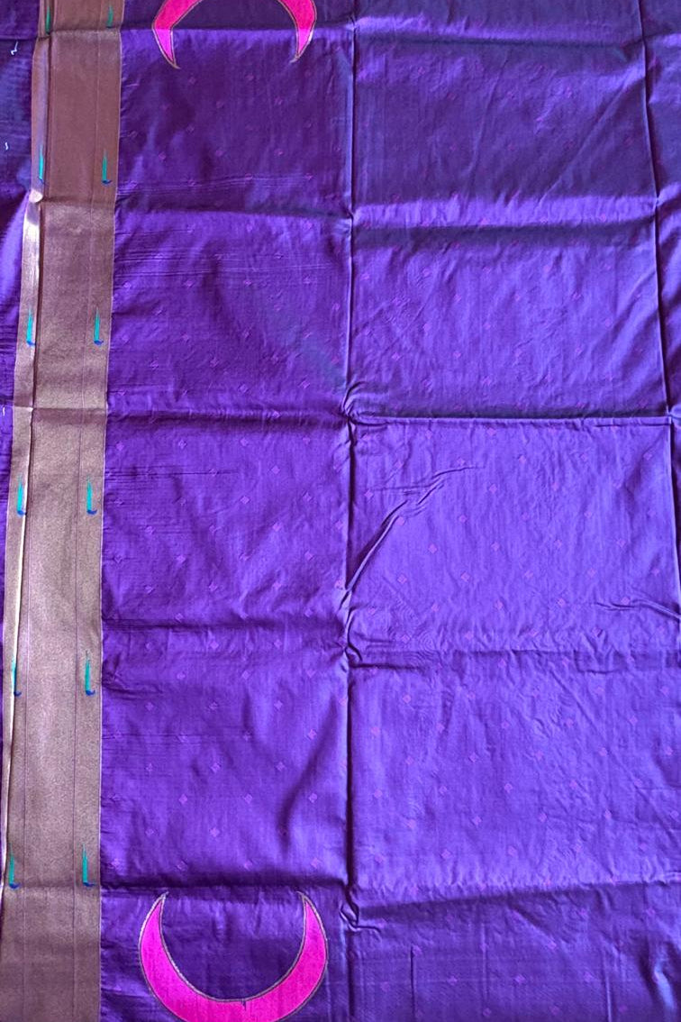 Purple fabric with pink crescent moon designs on a plain background